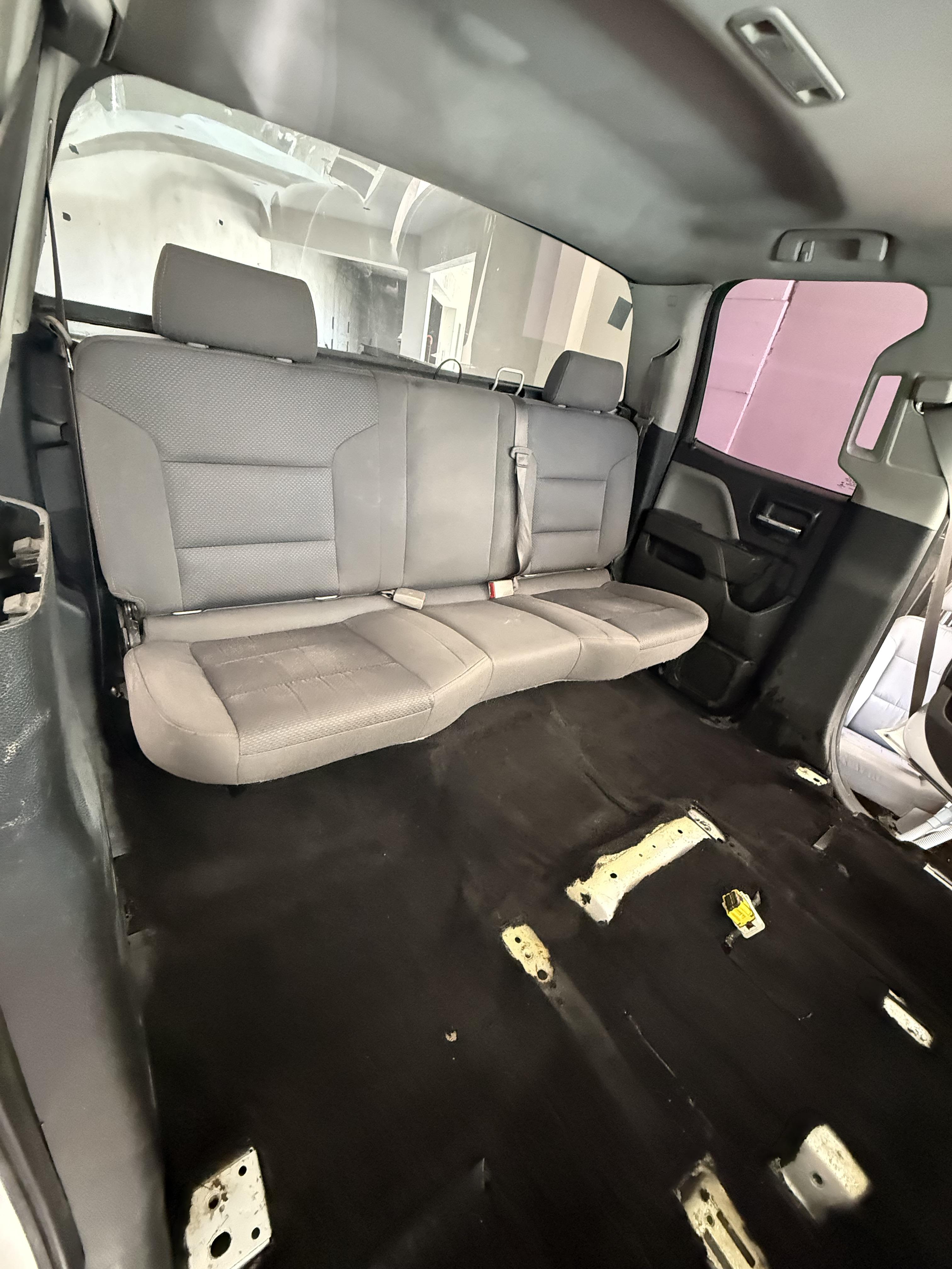 Interior de un vehículo con asientos traseros visibles y espacio para los delanteros.