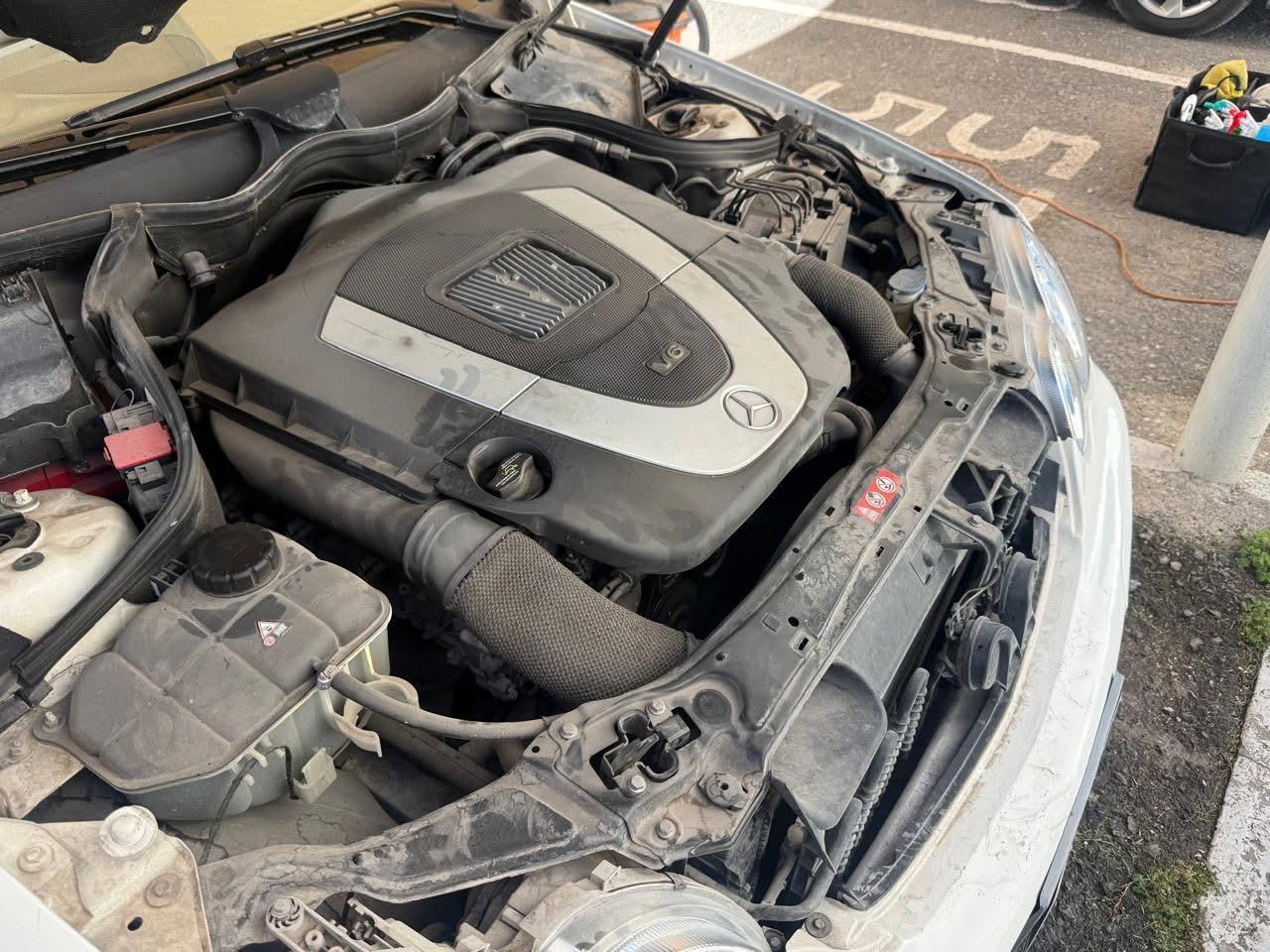 Motor de un automóvil con el cofre abierto, mostrando el compartimento del motor.